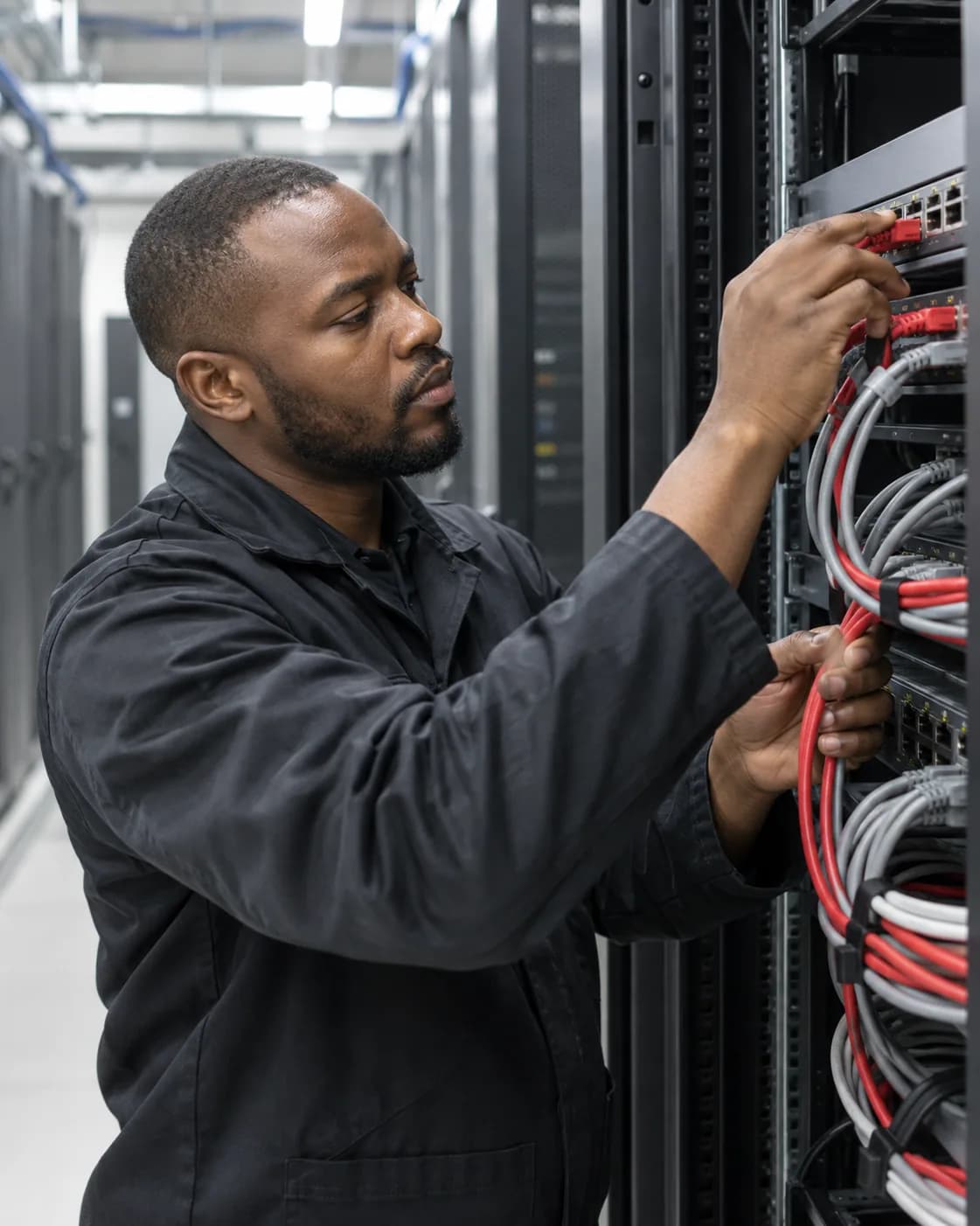 A technician connecting network cables in a server rack.