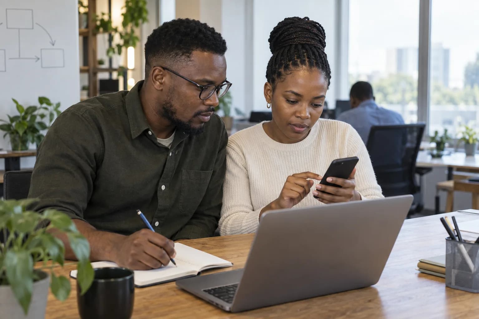 A developer and a product owner testing a mobile app on a phone.
